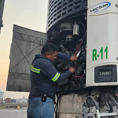 Una persona dando mantenimiento preventivo a un equipo de enfriamiento movil Carier.